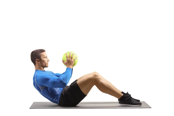 Jongeman Sportkleding Traint Met Een Bal Vloer Een Trainingsmat Geïsoleerd — Stockfoto