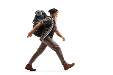 Sırt çantalı bir sakallı yürüyüşçünün beyaz arka planda hızla yürürken tam boy profil fotoğrafı.