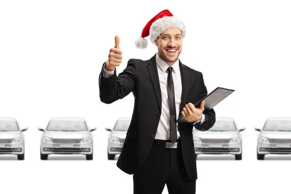 Car Dealer Wearing Santa Claus Hat Showing Thumbs Showroom Isolated — Stock Photo, Image