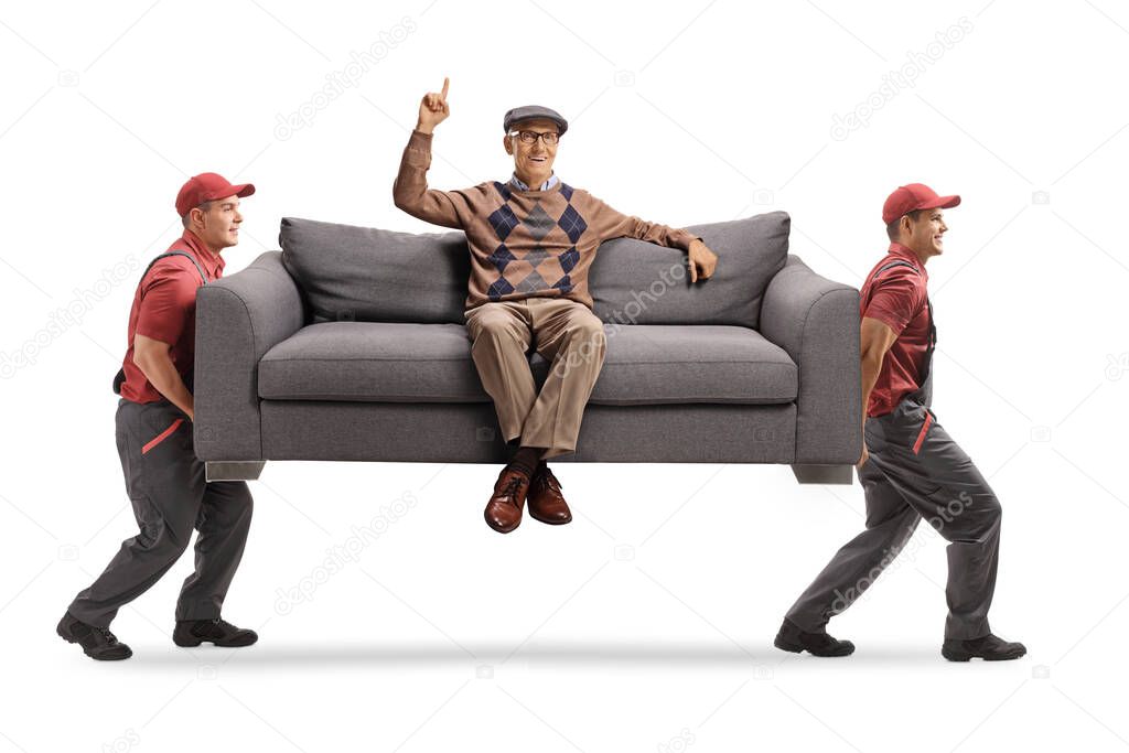 Movers carrying an elderly man sitting on a sofa and pointing up isolated on white background