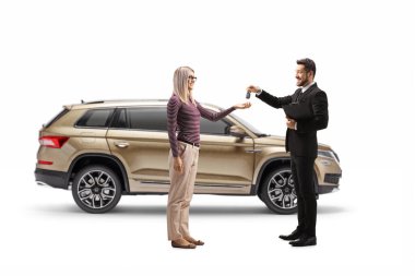 Satıcı beyaz arka planda izole edilmiş sarışın bir kadına SUV araba anahtarları veriyor.