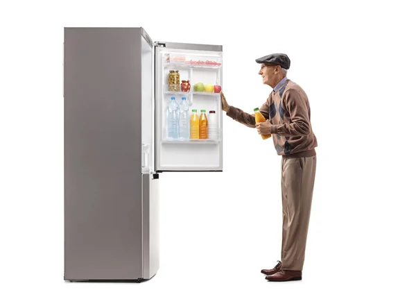 Пожилой Человек Открывает Холодильник Держит Бутылку Сока Изолированы Белом Фоне — стоковое фото