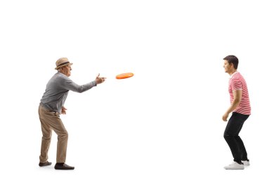 Yaşlı bir adamın beyaz arka planda izole edilmiş genç bir adamla plastik disk attığı uzun bir çekim.