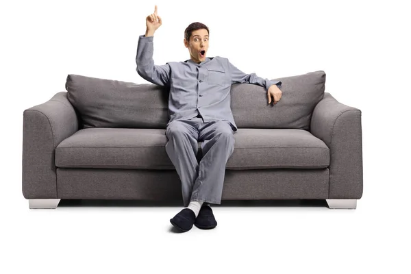 Young Man Pajamas Seated Sofa Pointing Isolated White Background — Stock Photo, Image