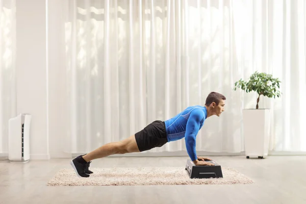 Jongeman Oefent Push Ups Een Stap Aërobe Platform Thuis — Stockfoto