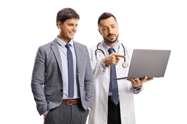 医者はスーツの男とノートパソコンの画面を指して白い背景に隔離されたネクタイ — ストック写真