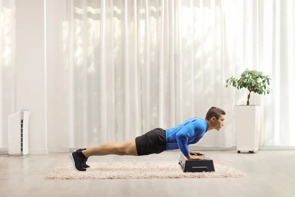 Kaslı Adam Odanın Içinde Aerobik Bir Basamakta Kalas Egzersizi Yapıyor — Stok fotoğraf