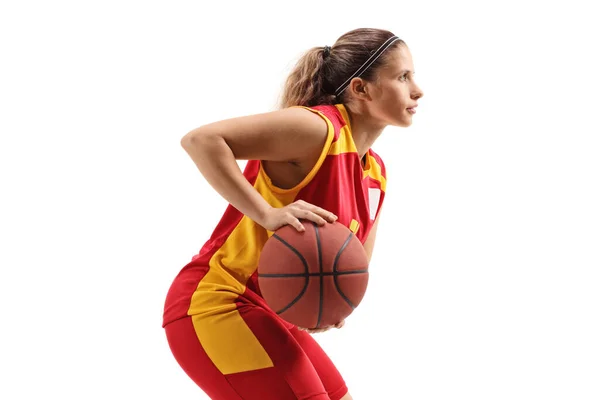 白地に孤立したボールを持つ赤と黄色のジャージの女性バスケットボール選手のプロフィールショット — ストック写真
