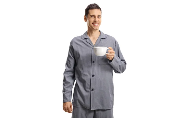 Leende Ung Man Pyjamas Håller Kopp Isolerad Vit Bakgrund — Stockfoto