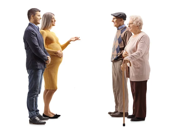 Full Length Profile Shot Young Expecting Couple Talking Elderly Couple — Stock Photo, Image