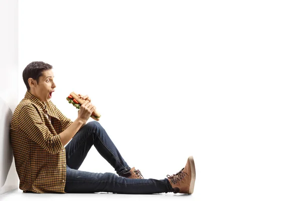 Jeune Homme Excité Avec Sandwich Assis Appuyé Sur Mur Isolé — Photo