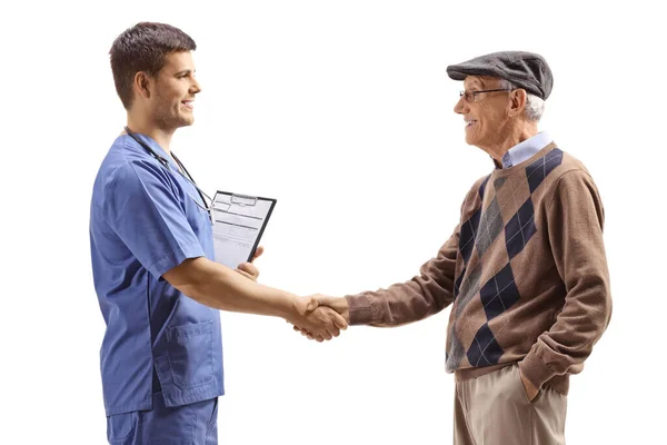 Médico Con Uniforme Azul Estrechando Mano Con Paciente Anciano Aislado — Foto de Stock