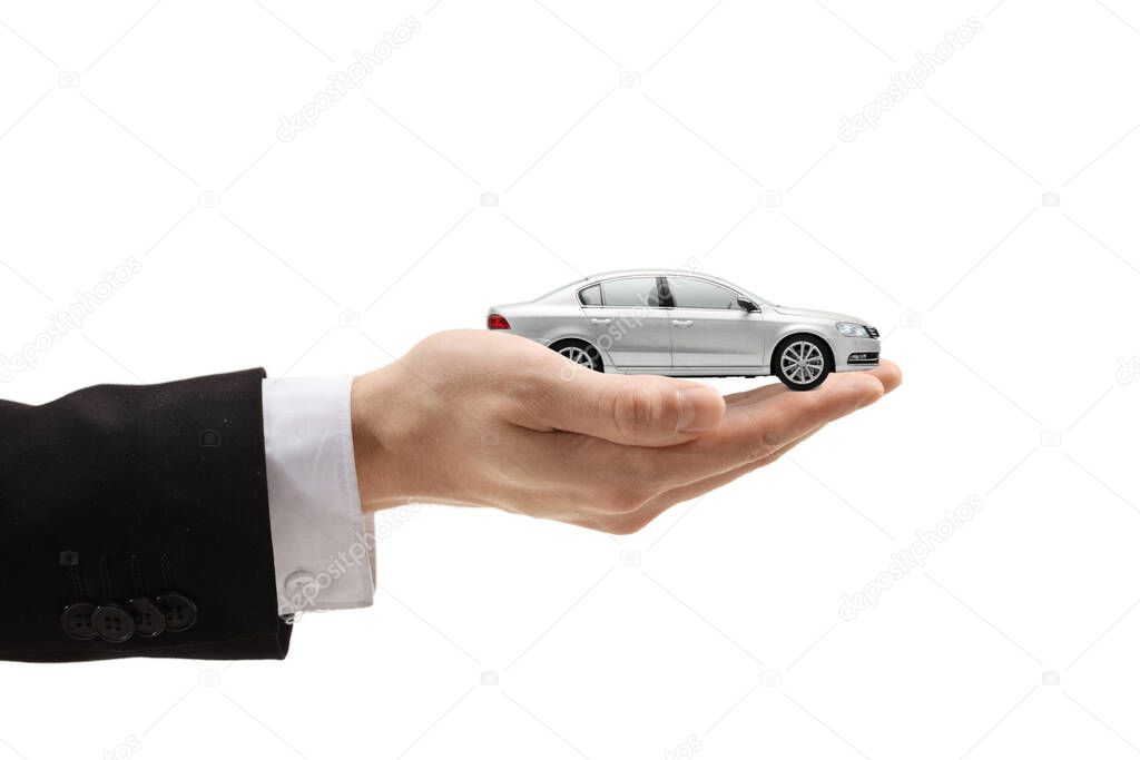 Male hand holding a silver model car isolated on white background