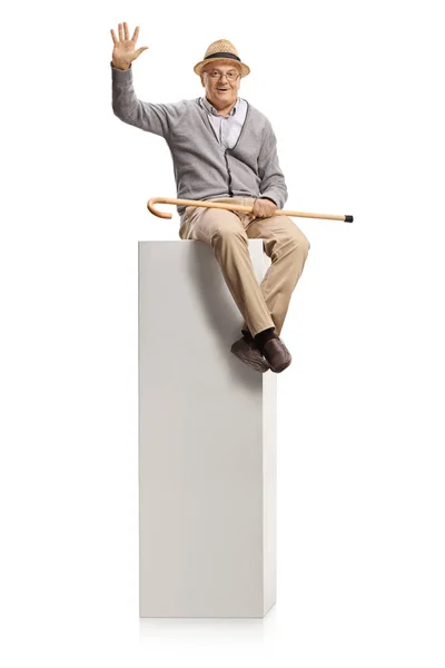 Anciano Con Bastón Sentado Una Columna Blanca Saludando Aislado Sobre — Foto de Stock