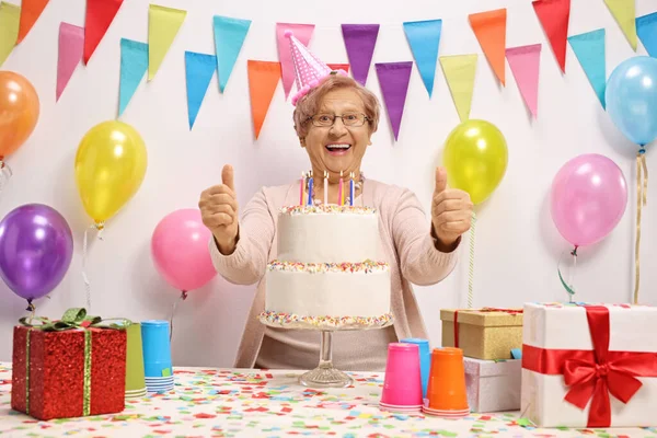 ケーキやキャンドルで誕生日を祝う興奮した高齢者の女性 誕生日プレゼントや風船 — ストック写真