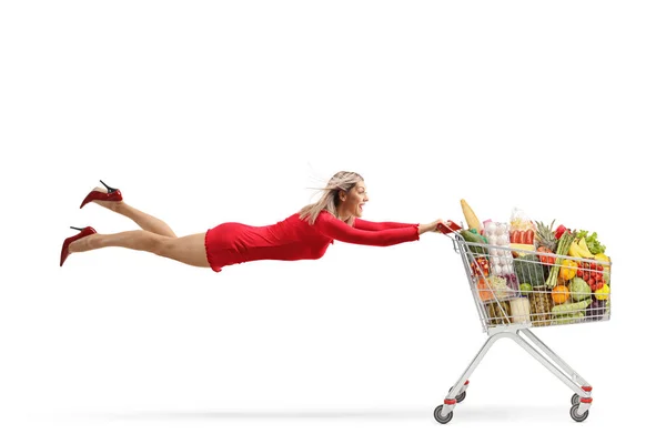 Mujer Atractiva Vestido Rojo Volando Sosteniendo Carrito Compras Completo Aislado — Foto de Stock