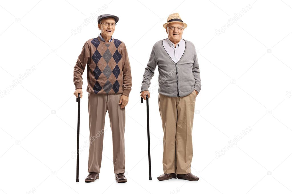 Full length portrait of elderly male friends standing with canes isolated on white background