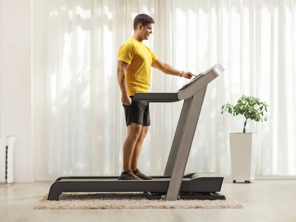 Full Length Profile Shot Young Man Sportswear Pushing Button Treadmill — Stock Photo, Image