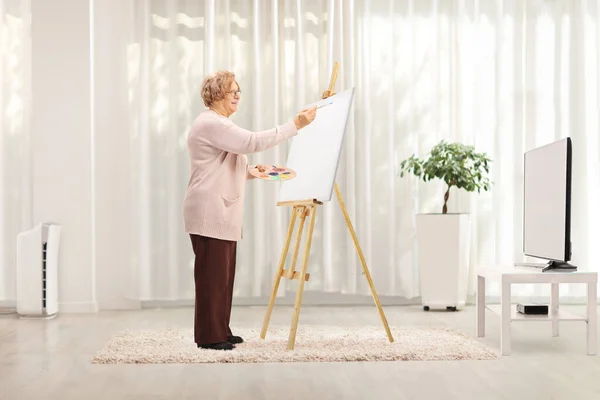 Ältere Frau Steht Hause Und Malt Auf Einer Leinwand — Stockfoto