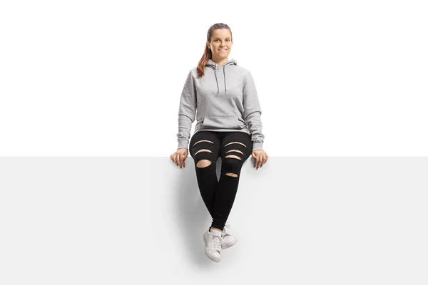 Smiling Young Female Hoodie Ripped Trousers Sitting Panel Isolated White — Stock Photo, Image