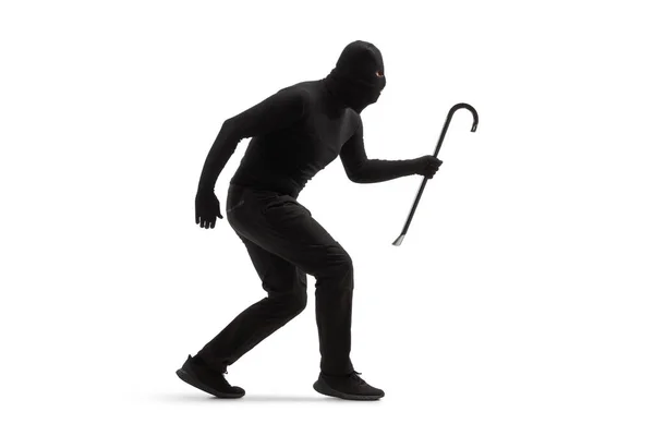 Полнометражный Снимок Грабителя Черной Одежде Балаклавой Ломом Идущим Медленно Изолированным — стоковое фото