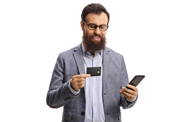 笑顔ひげを生やした男にクレジットカードを持っている眼鏡と白い背景に隔離されたスマートフォン — ストック写真