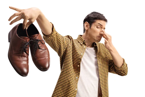 Hombre Bloqueándose Nariz Sosteniendo Par Zapatos Malolientes Aislados Sobre Fondo —  Fotos de Stock