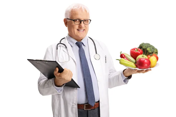 Ältere Männliche Arzt Hält Einen Teller Mit Gesundem Obst Und — Stockfoto