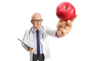Olgun bir doktor elinde bir dosya ve beyaz arka planda izole edilmiş kırmızı bir elma tutuyor.