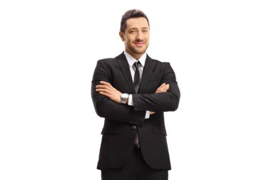 Siyah takım elbiseli genç bir işadamı beyaz arka planda kollarını kavuşturup poz veriyor.