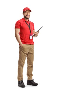 Elinde bir pano tutan ve beyaz arka planda izole bir şekilde gülümseyen bir erkek tezgahtarın tam boy portresi.