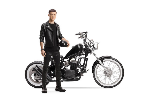 Full length portrait of a guy holding helmet and posing with a chopper isolated on white background