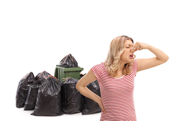 Walgelijke Vrouw Sluiten Haar Neus Voorkant Van Een Afvalbak Geïsoleerd — Stockfoto