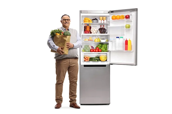 Портрет Взрослого Мужчины Пакетом Продуктов Стоящим Рядом Открытым Холодильником Белом — стоковое фото