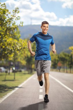 Spor giyim sektöründe genç bir adam şehirde koşuyor.