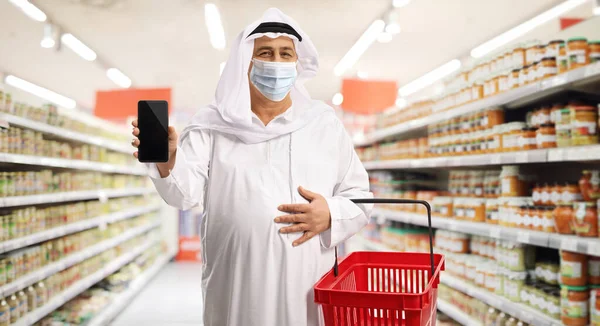 Starší Arabský Muž Nákupním Košíkem Smartphonem Ochrannou Maskou Uvnitř Supermarketu — Stock fotografie