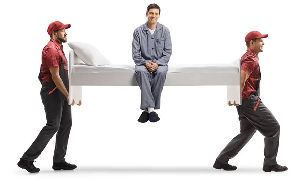 Movers Carrying Single Bed Man Seated Pajamas Isolated White Background — Stock Photo, Image