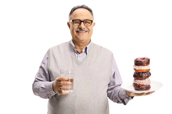 Щасливий Зрілий Чоловік Тримає Склянку Води Тарілку Шоколадних Пончиків Ізольовані — стокове фото