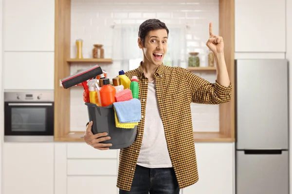 Young Man Bucket Full Cleaning Supplies Kitchen Pointing Looking Camera — Stock Photo, Image