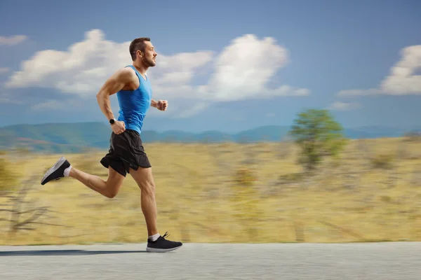 Full Length Profil Záběr Mladého Muže Jogging Otevřené Silnici — Stock fotografie