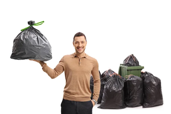 Junger Mann Mit Einem Müllsack Vor Einem Mülleimer Auf Weißem — Stockfoto