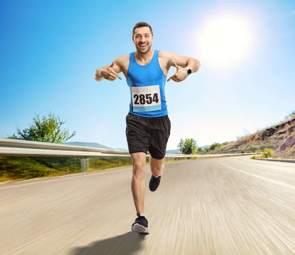 Portret Mężczyzny Biegnącego Maratonie Wskazującego Swój Numer — Zdjęcie stockowe