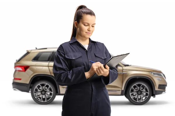 Joven Mecánica Femenina Escribiendo Portapapeles Pie Frente Suv Aislado Sobre — Foto de Stock