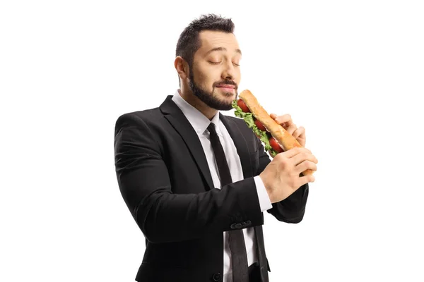 ビジネスマンはバゲットでサンドイッチを食べ 白い背景に隔離された楽しみ — ストック写真