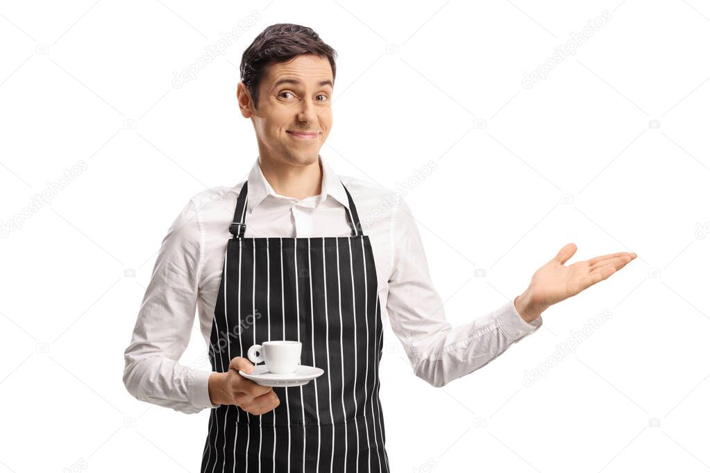 Barista with an apron holding an espresso coffee and showing with hand isolated on white background