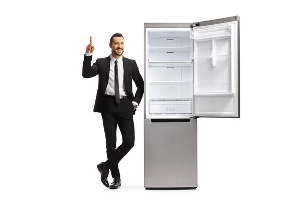 Full Length Portrait Businessman Leaning Empty Fridge Pointing Isolated White — Stock Photo, Image