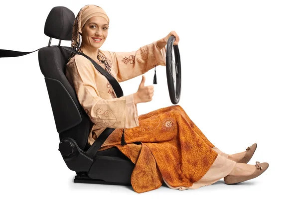 若いですムスリム女性で車の座席にステアリングホイールとジェスチャー親指アップ上の白の背景に隔離 — ストック写真