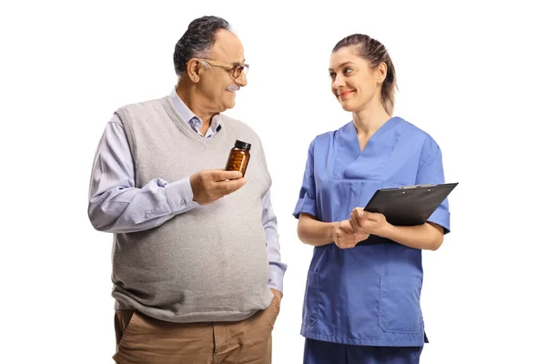 Mature Man Holding Bottle Pills Looking Young Female Nurse Isolated — Stock Photo, Image