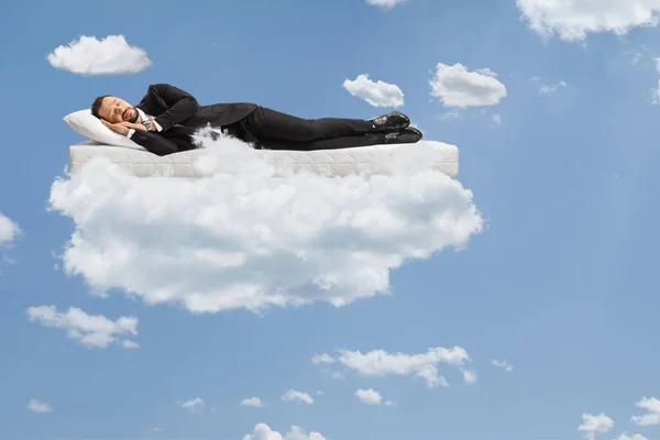 Businessman Suit Tie Sleeping Mattress Floating Clouds Blue Sky — Stock Photo, Image