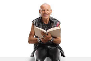 Kel adam panelde kitap okuyor ve beyaz arka planda izole edilmiş kameraya gülümsüyor.